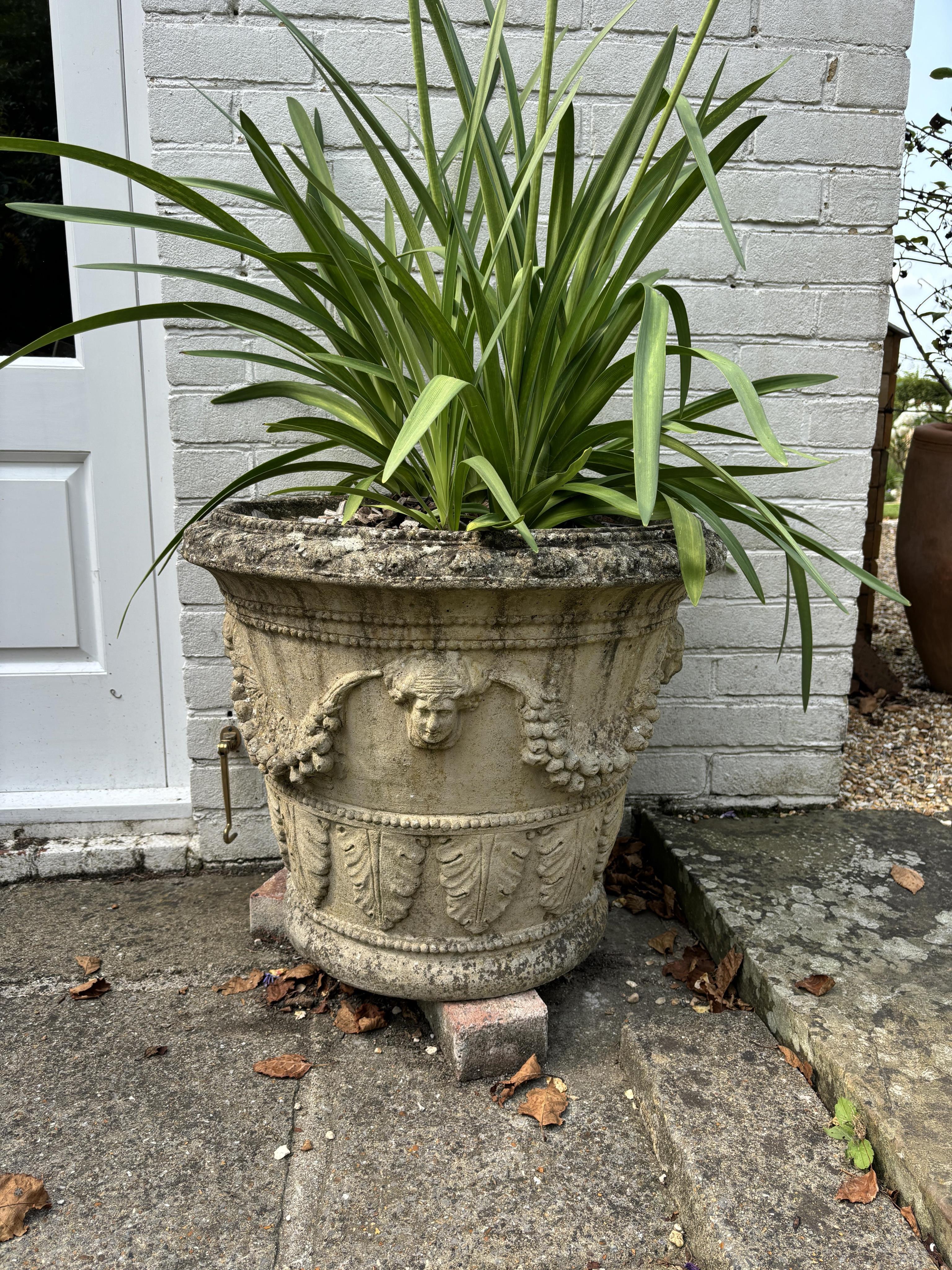 A pair of circular reconstituted stone garden urns, height 50cm, depth 60cm. planting removed. Condition - weathered otherwise good